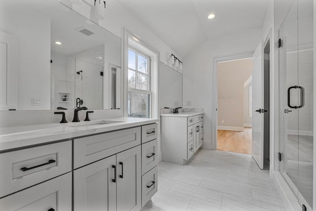 full bath featuring visible vents, two vanities, recessed lighting, a sink, and a shower stall