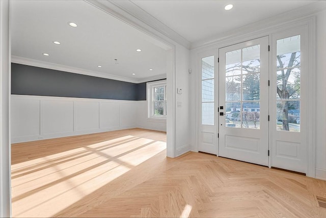 entryway with wainscoting, recessed lighting, and ornamental molding