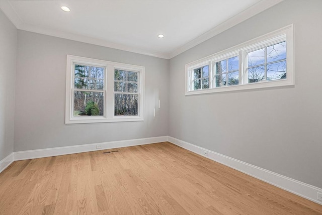 spare room with baseboards, light wood-style floors, and ornamental molding