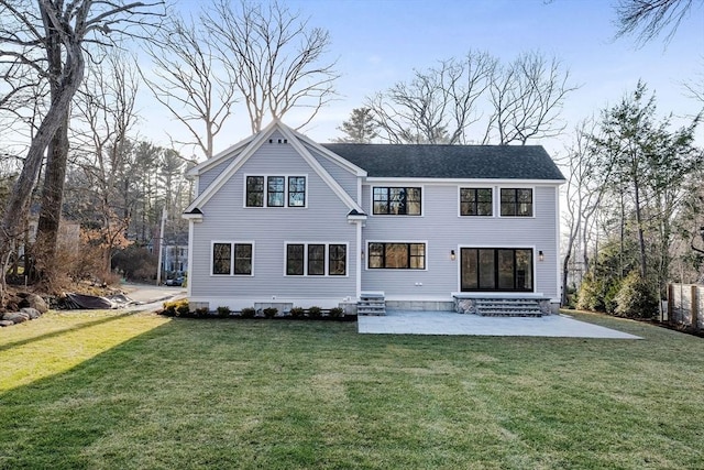 rear view of property featuring entry steps, a yard, and a patio area