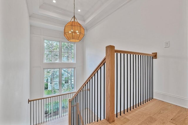 stairs featuring wood finished floors, a high ceiling, recessed lighting, ornamental molding, and a chandelier