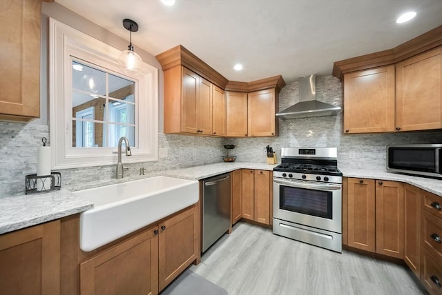 80 E St, Pepperell, MA 01463 - kitchen featuring appliances with stainless steel finishes, wall chimney range hood, backsplash, brown cabinets, and light wood-style flooring