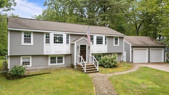 80 E St, Pepperell, MA 01463 - raised ranch featuring a front lawn, driveway, an attached garage, and roof with shingles