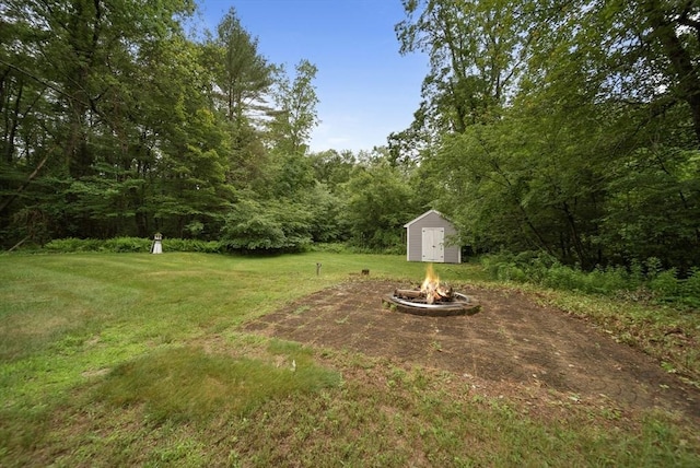 80 E St, Pepperell, MA 01463 - view of grassy yard with an outdoor fire pit, a shed, and a forest view
