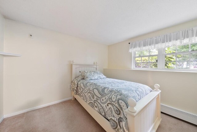 80 E St, Pepperell, MA 01463 - bedroom featuring a baseboard heating unit and light colored carpet