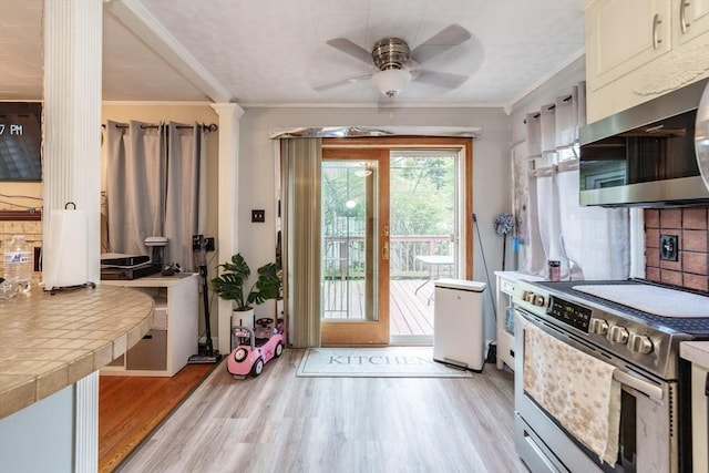 276 Oak St, Springfield, MA 01151 - kitchen with appliances with stainless steel finishes, light wood-style floors, tile countertops, a ceiling fan, and crown molding