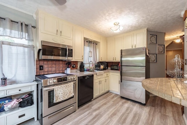 276 Oak St, Springfield, MA 01151 - kitchen with appliances with stainless steel finishes, a sink, healthy amount of natural light, and light wood finished floors