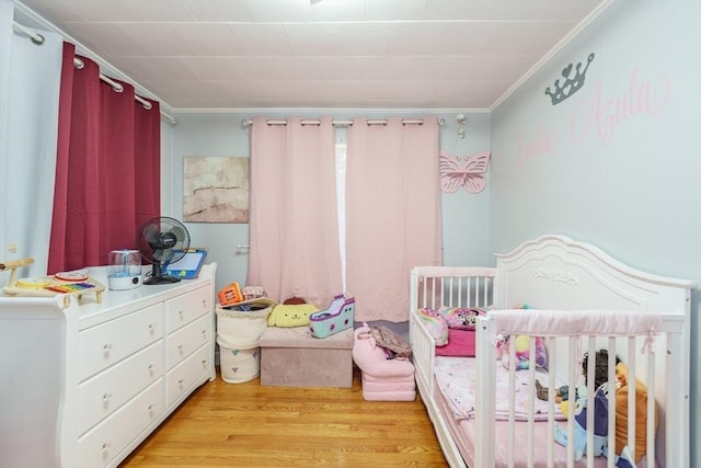 276 Oak St, Springfield, MA 01151 - bedroom featuring crown molding, a nursery area, and light wood finished floors