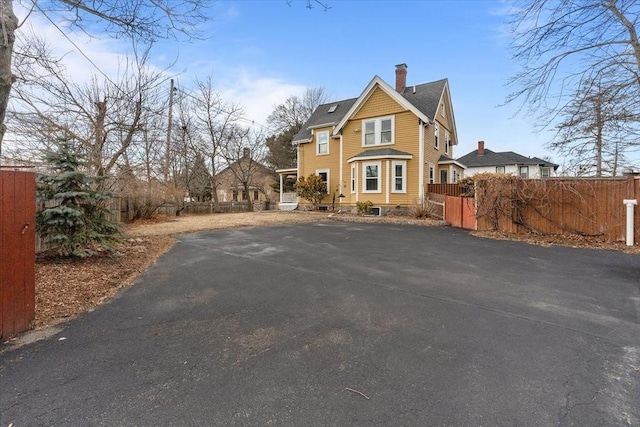 view of front of property with a chimney and fence