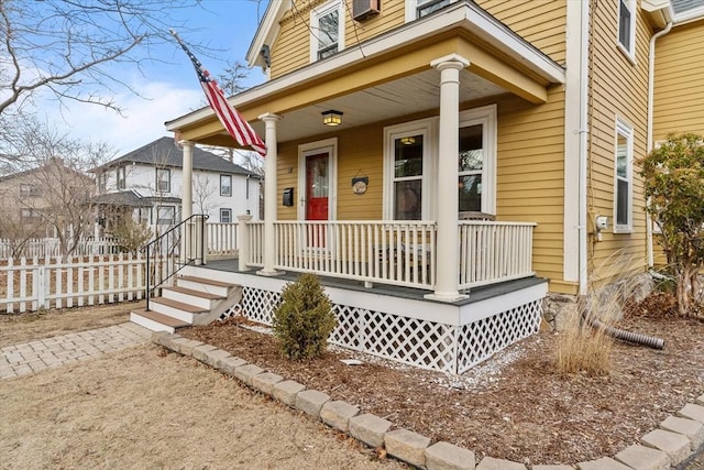 property entrance with a porch and fence