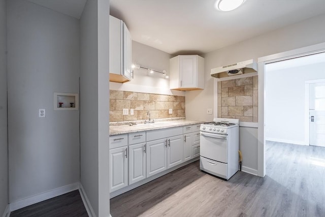 kitchen featuring white cabinetry, sink, decorative backsplash, white range with gas stovetop, and light hardwood / wood-style flooring