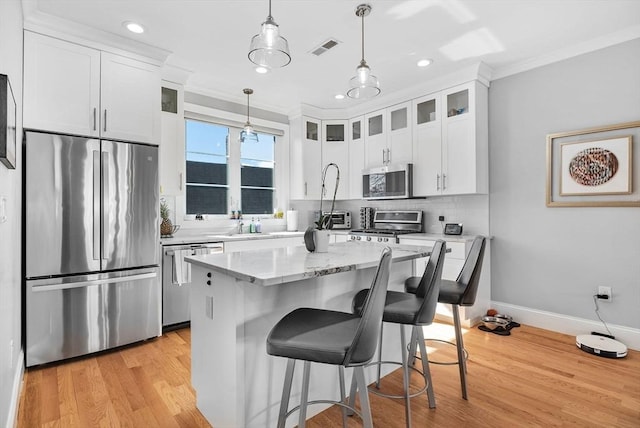 kitchen with visible vents, backsplash, appliances with stainless steel finishes, light wood-style floors, and white cabinetry