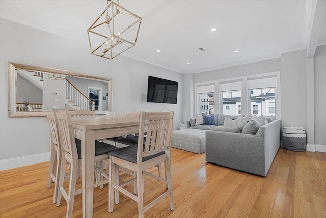 dining space featuring crown molding, recessed lighting, wood finished floors, baseboards, and stairs