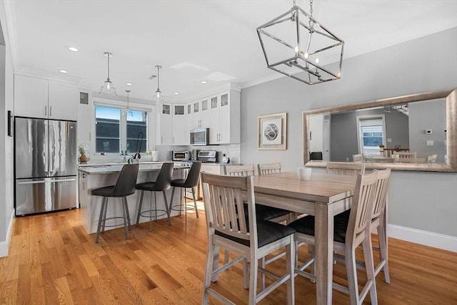 dining area featuring crown molding, recessed lighting, a chandelier, light wood-type flooring, and baseboards