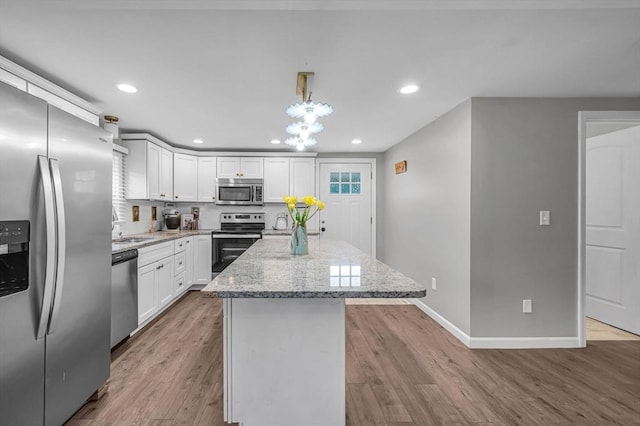151 Labelle St, West Springfield, MA 01089 - kitchen with appliances with stainless steel finishes, a center island, recessed lighting, wood finished floors, and light stone countertops