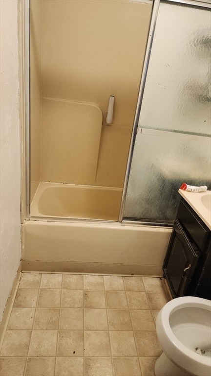 full bathroom featuring vanity, toilet, and bath / shower combo with glass door