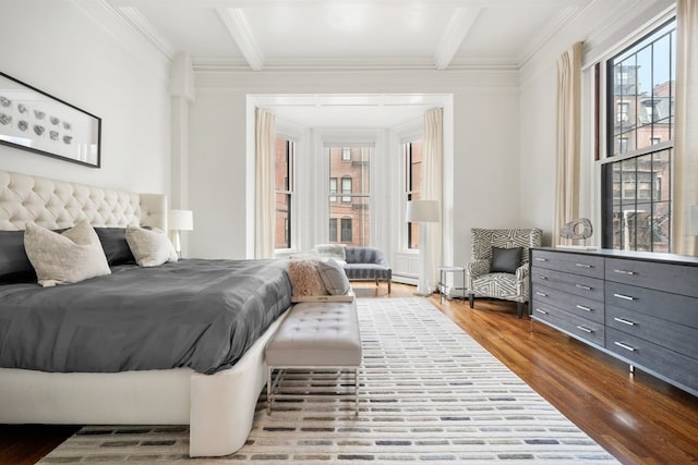 bedroom with beam ceiling, crown molding, and hardwood / wood-style floors