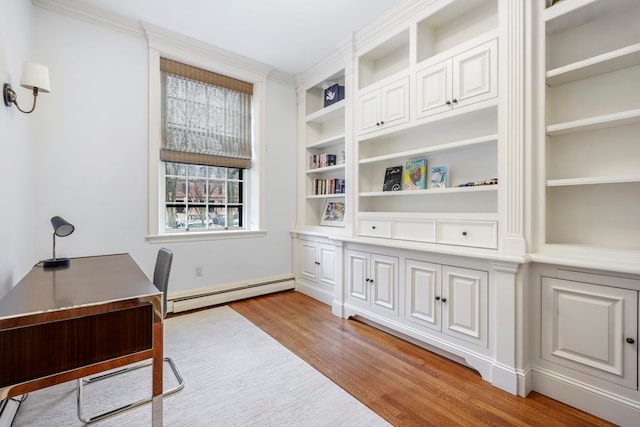 office space featuring light hardwood / wood-style floors, ornamental molding, built in features, and a baseboard radiator