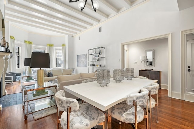 dining space with beamed ceiling, ornamental molding, dark wood-type flooring, and a chandelier