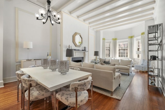 dining space featuring beamed ceiling, dark hardwood / wood-style flooring, a chandelier, and crown molding