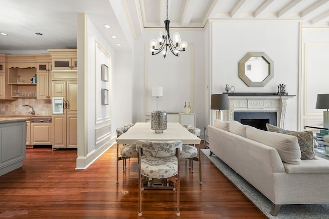 dining space featuring beamed ceiling, dark hardwood / wood-style flooring, a chandelier, and a brick fireplace