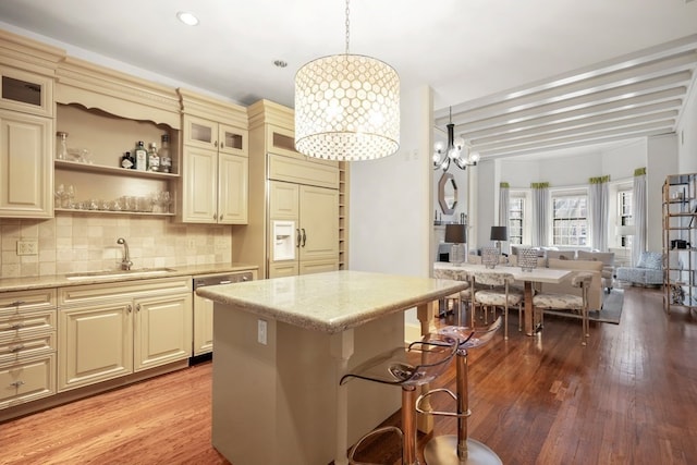 kitchen featuring cream cabinetry, pendant lighting, hardwood / wood-style flooring, and sink