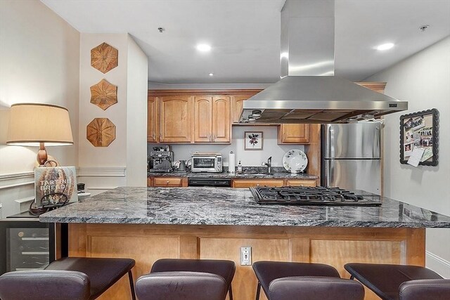 110 O St Unit 1, Boston, MA 02127 - kitchen featuring cooktop, freestanding refrigerator, island exhaust hood, and a kitchen breakfast bar