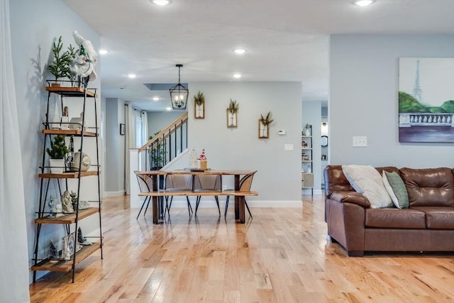 living room featuring light wood-type flooring and a chandelier