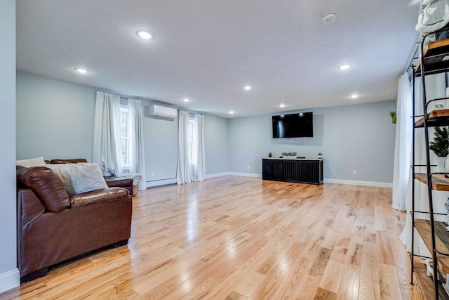 living room featuring light hardwood / wood-style floors, an AC wall unit, and a baseboard heating unit