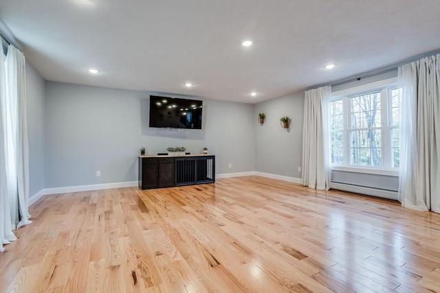 unfurnished living room featuring a baseboard radiator and light hardwood / wood-style flooring