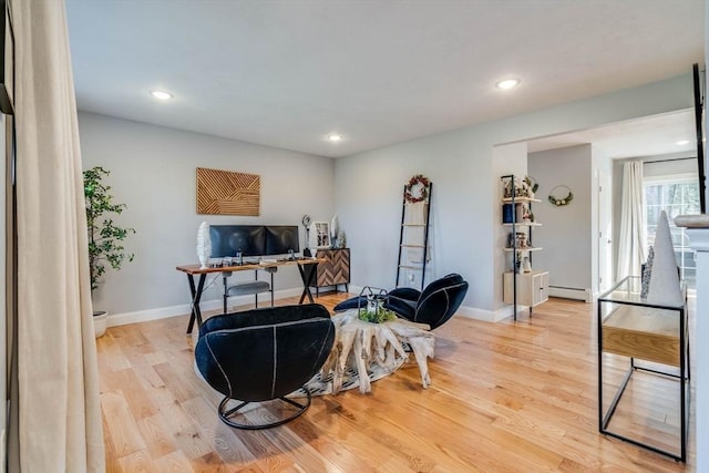 home office featuring a baseboard heating unit and light wood-type flooring