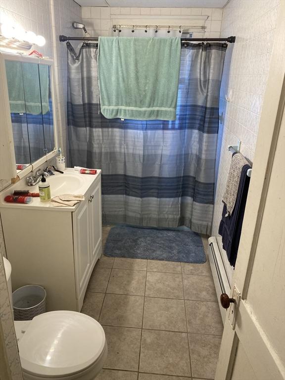 bathroom featuring vanity, tile patterned floors, a shower with shower curtain, and a baseboard radiator