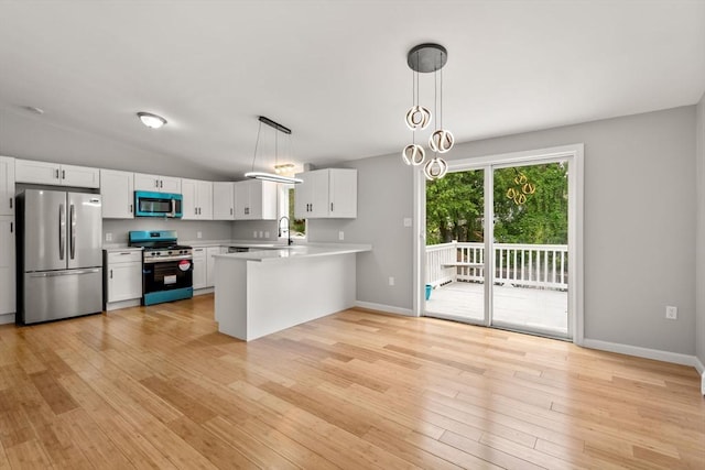 29 Hudson Ave, Southbridge, MA 01550 - kitchen featuring stainless steel appliances, light countertops, a peninsula, light wood finished floors, and vaulted ceiling
