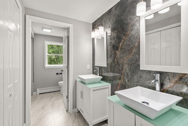 29 Hudson Ave, Southbridge, MA 01550 - full bath with baseboard heating, marble finish floors, two vanities, toilet, and decorative backsplash