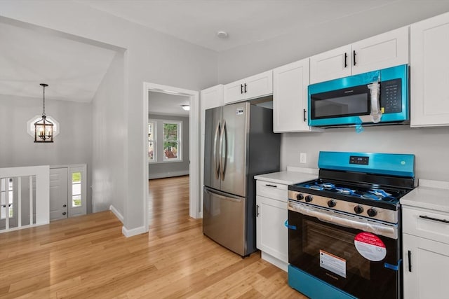 29 Hudson Ave, Southbridge, MA 01550 - kitchen featuring appliances with stainless steel finishes, light countertops, light wood-style floors, a chandelier, and white cabinets