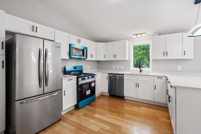 29 Hudson Ave, Southbridge, MA 01550 - kitchen featuring stainless steel appliances, a sink, light countertops, white cabinets, and light wood-type flooring