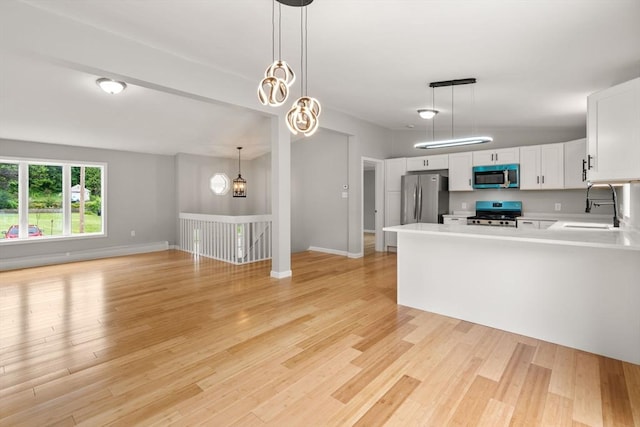 29 Hudson Ave, Southbridge, MA 01550 - kitchen with stainless steel appliances, a sink, light countertops, light wood-type flooring, and white cabinetry