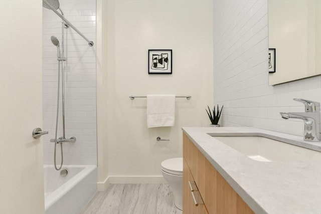 full bathroom with toilet, vanity, and tiled shower / bath combo