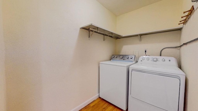 laundry room featuring light wood finished floors, laundry area, baseboards, and separate washer and dryer