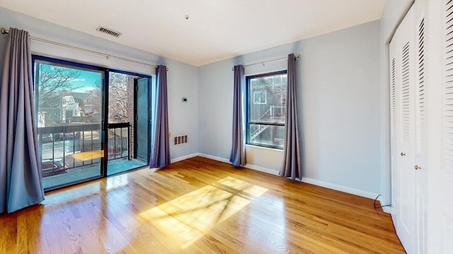 empty room featuring visible vents, baseboards, and light wood-style flooring