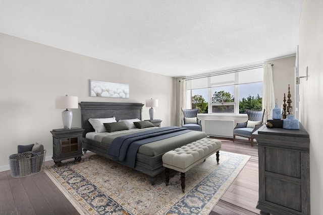 280 Boylston St Unit 511, Newton, MA 02467 - bedroom with wood finished floors, baseboards, and a wood stove