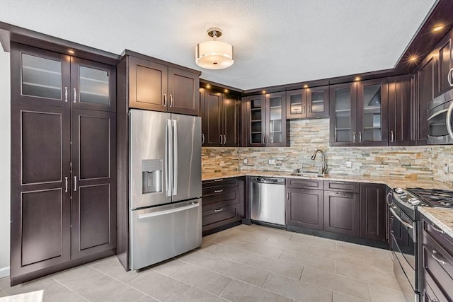 280 Boylston St Unit 511, Newton, MA 02467 - kitchen with stainless steel appliances, light tile patterned flooring, a sink, and dark brown cabinets
