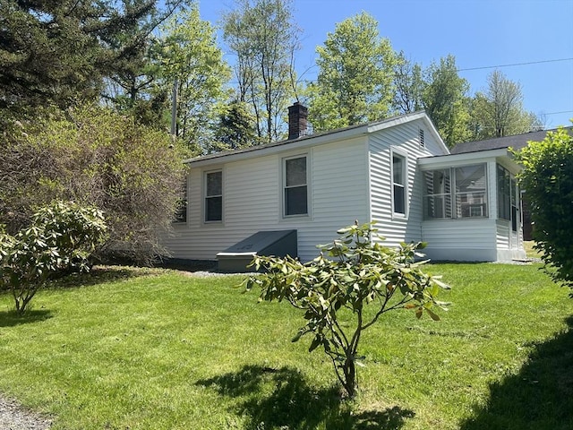 26A Duval Ct, Winchendon, MA 01475 - view of property exterior featuring a chimney, a yard, and a sunroom