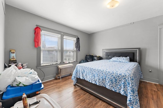 bedroom with hardwood / wood-style flooring and radiator