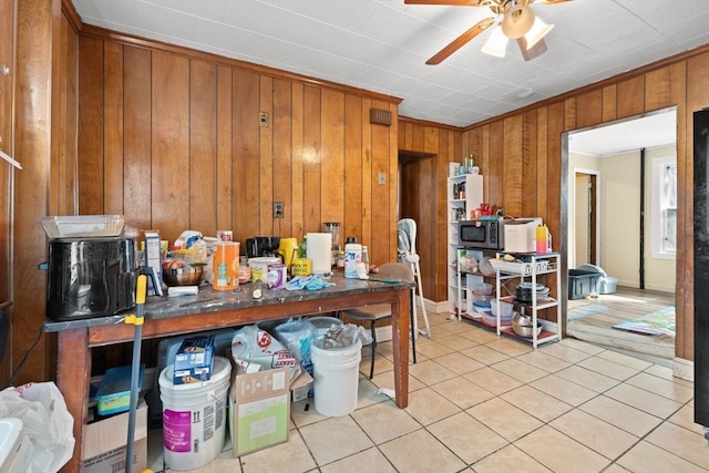 interior space with crown molding, wooden walls, and light tile patterned floors