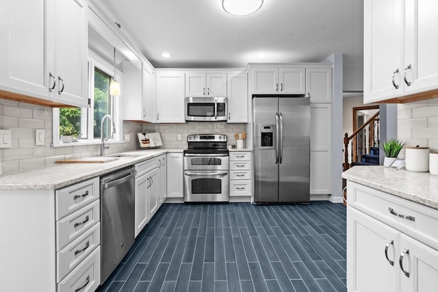 26 Emery Ct, Stoneham, MA 02180 - kitchen featuring stainless steel appliances, backsplash, white cabinetry, light stone countertops, and recessed lighting