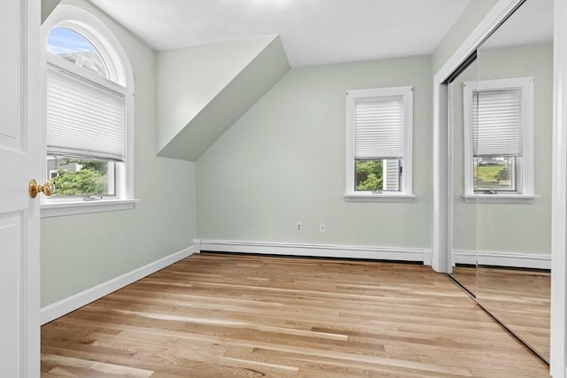26 Emery Ct, Stoneham, MA 02180 - additional living space with baseboard heating, light wood-style floors, and vaulted ceiling