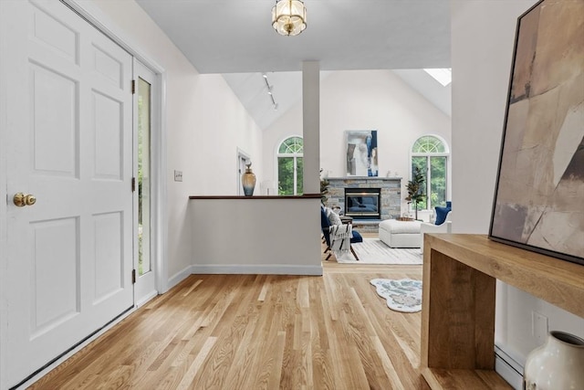 26 Emery Ct, Stoneham, MA 02180 - entrance foyer with light wood-type flooring, vaulted ceiling, plenty of natural light, and a baseboard radiator