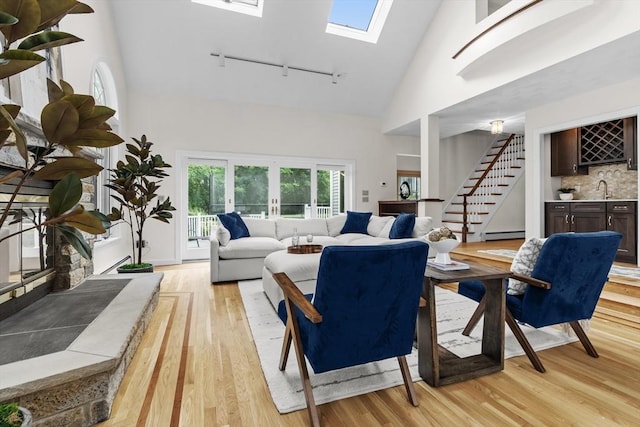 26 Emery Ct, Stoneham, MA 02180 - living room with rail lighting, high vaulted ceiling, light wood-style floors, stairway, and bar with sink