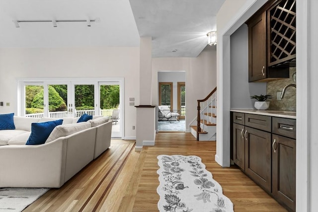 26 Emery Ct, Stoneham, MA 02180 - living room with track lighting, french doors, stairs, and light wood-style flooring